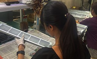 worker packing aluminium handles into cartons